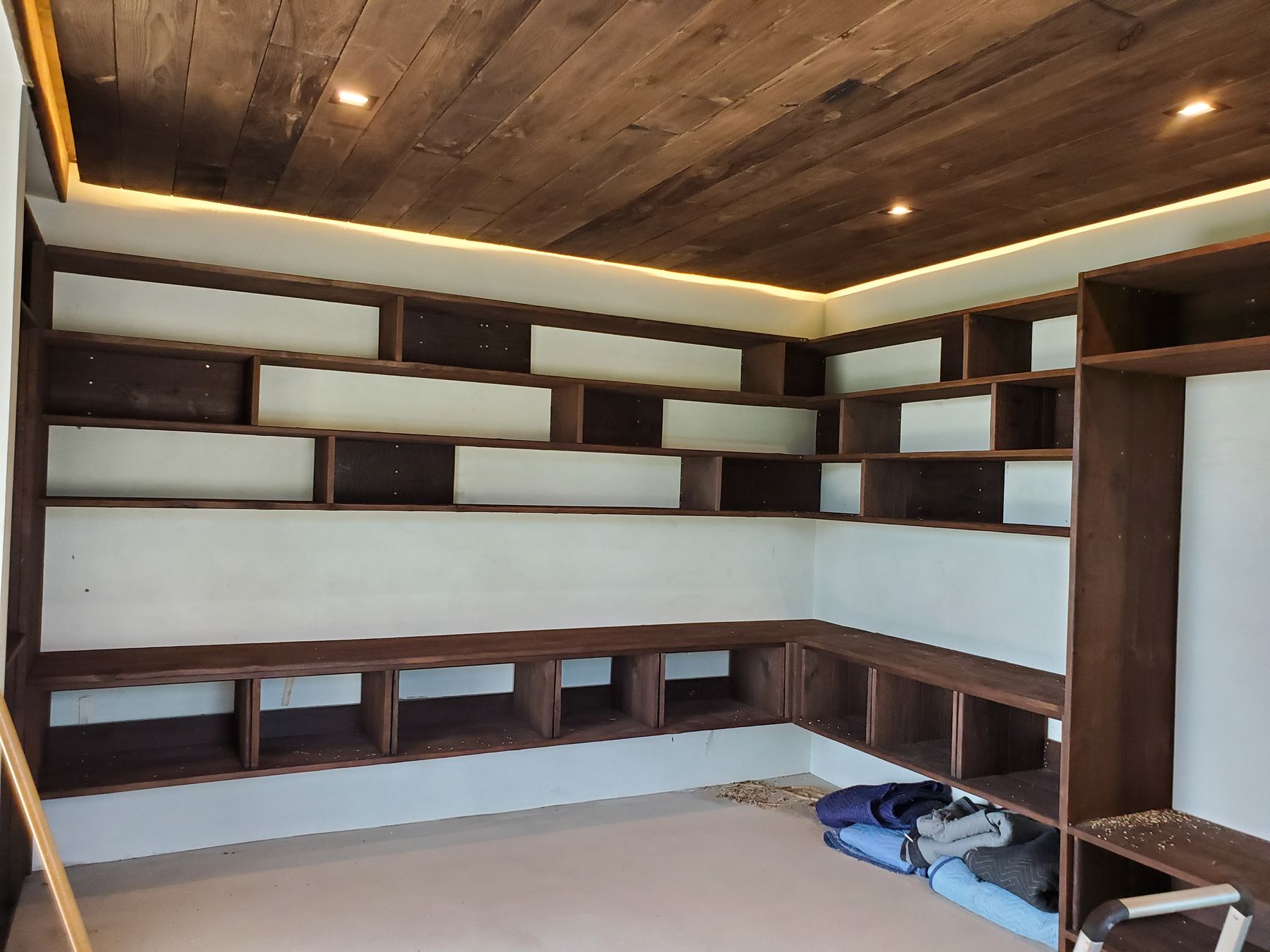 Collingwood, Floor-to-ceiling shelving and bench cabinets under a lit wood ceiling