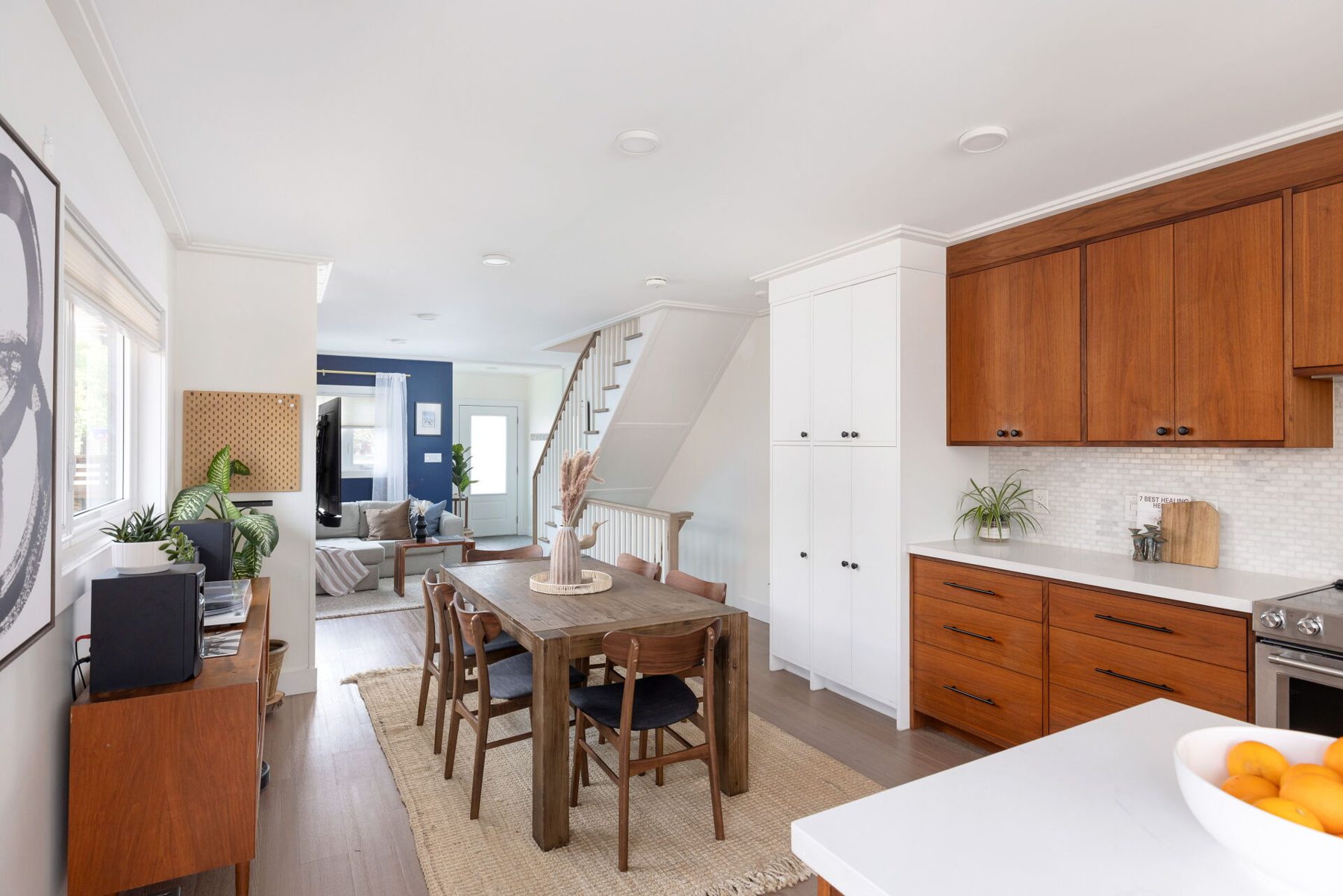 Kitchen, Walnut cabinets and drawers with a white pantry wall and open stair